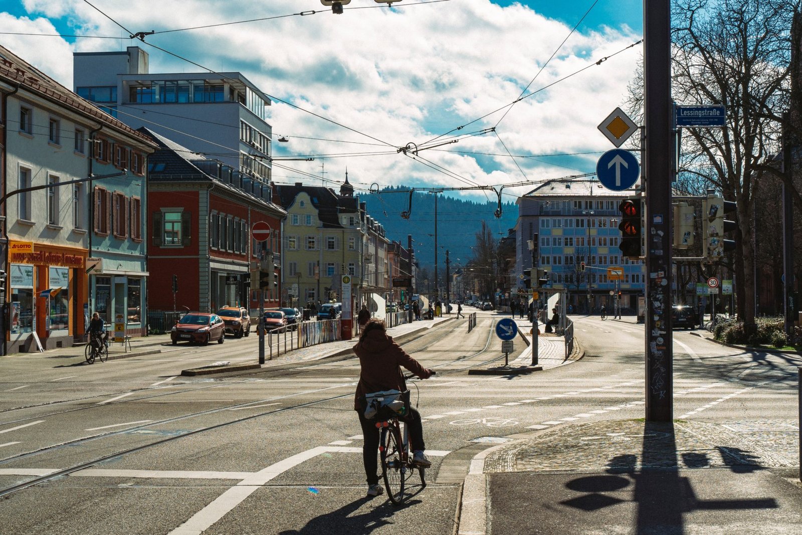 woman in black jacket riding bicycle on road during daytime